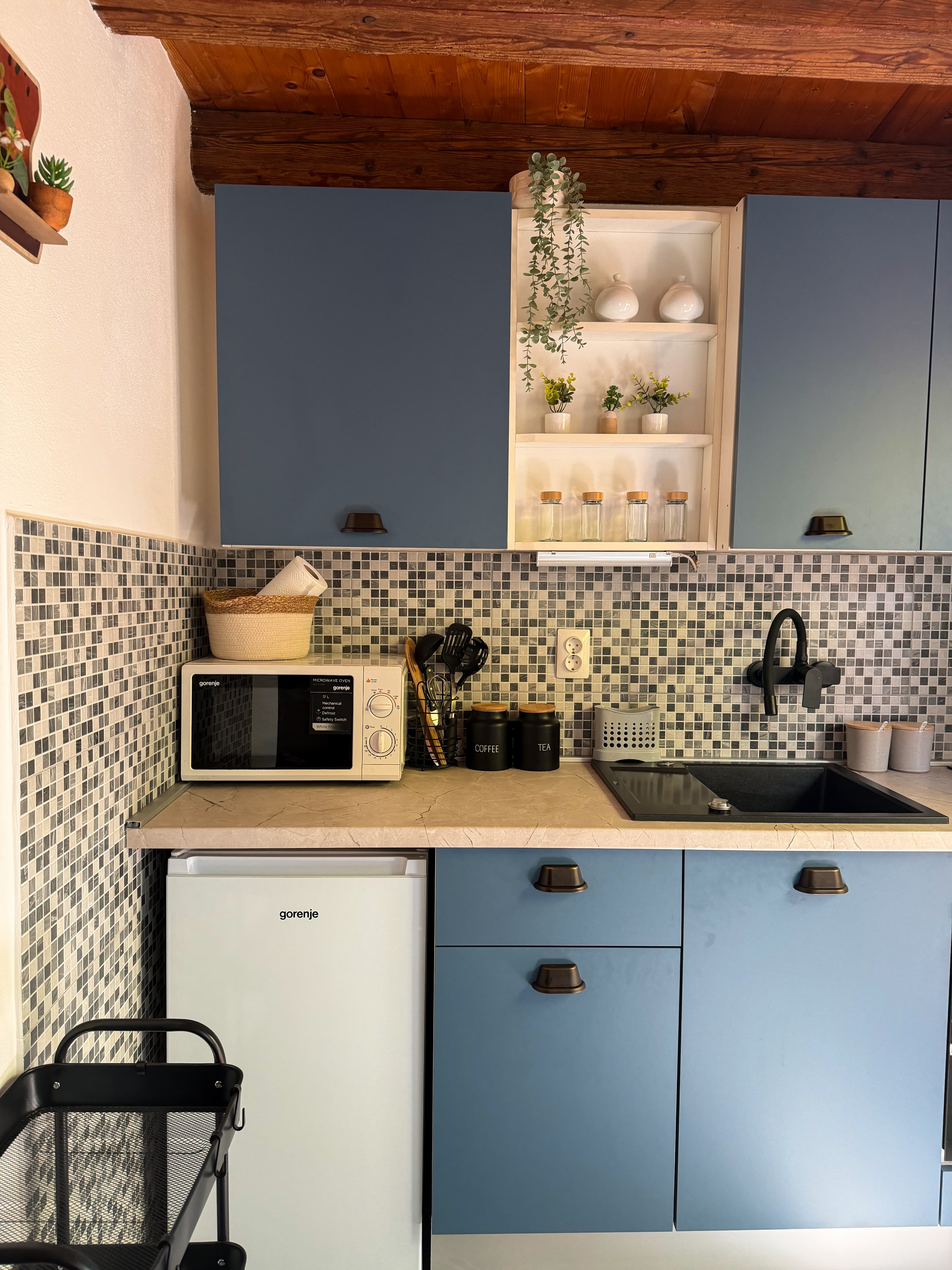 Renovirana kuhinja u steel blue tonu s mozaik pločicama, crnim mat detaljima i drvenim stropom u dalmatinskoj kamenoj kućici
